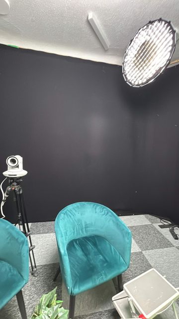 Le plateau de La Chaîne Varoise en fond noir : deux fauteuils, une caméra motorisée sur pied et une boîte à lumière parabolique équipée d’un nid d’abeille en surplomb.