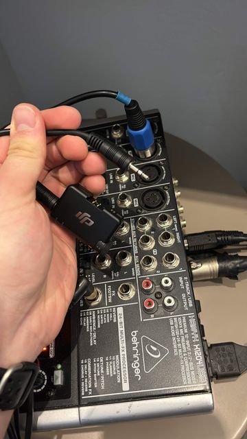 Un récepteur de micro-cravate sans fil branché sur une des entrées de la console de mixage.